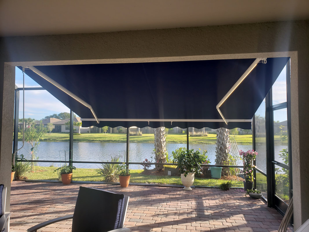 A patio covered with a blue awning next to a lake