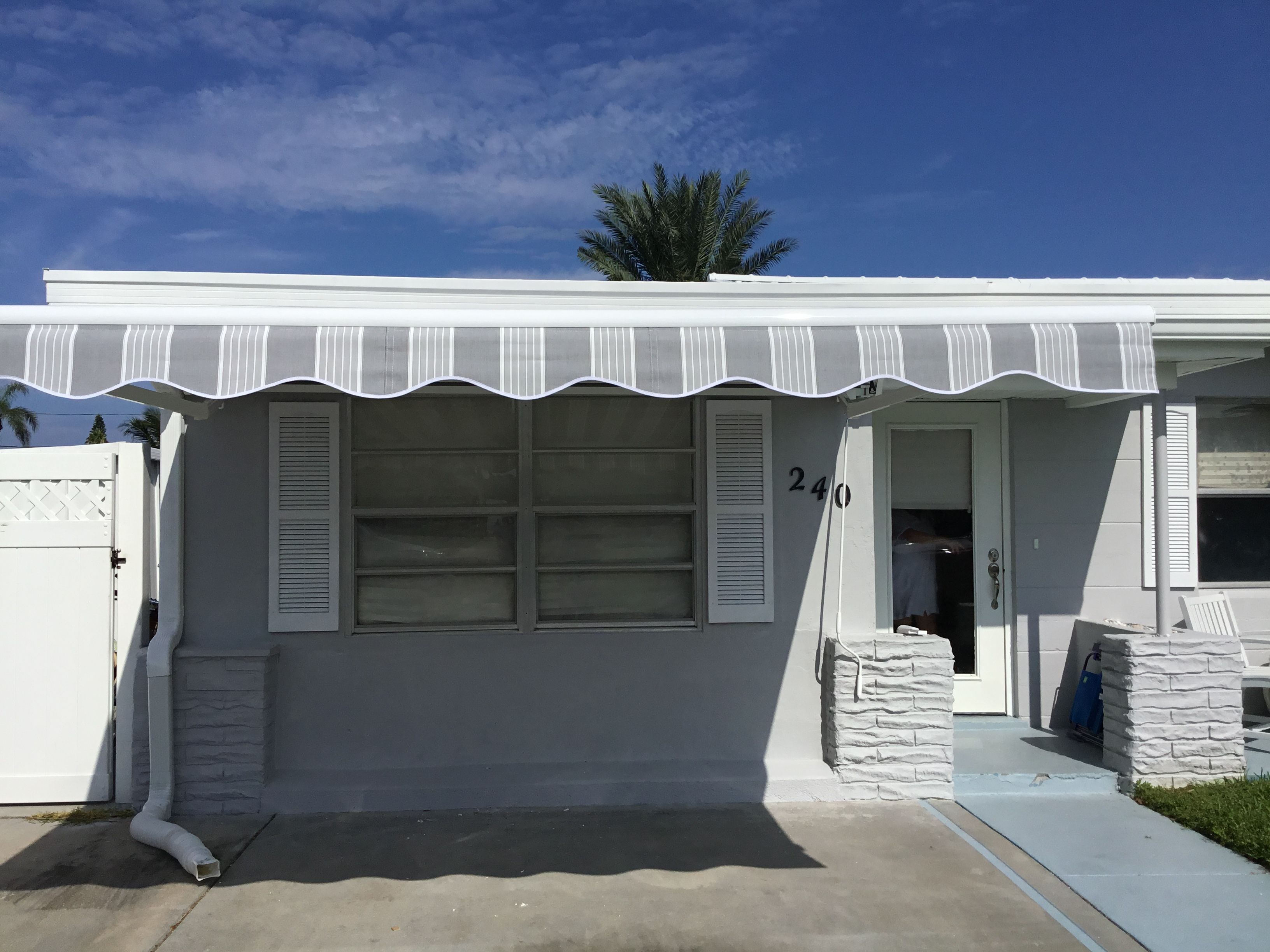 A small white house with a white awning