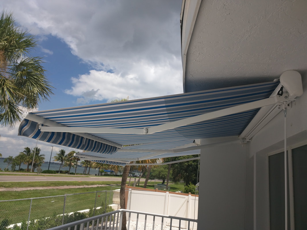 A blue and white striped awning over a balcony