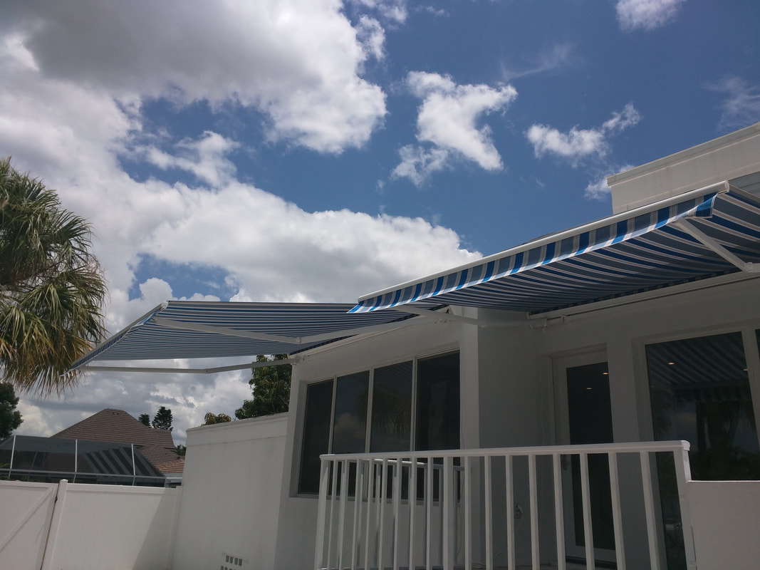 A white house with a blue and white awning