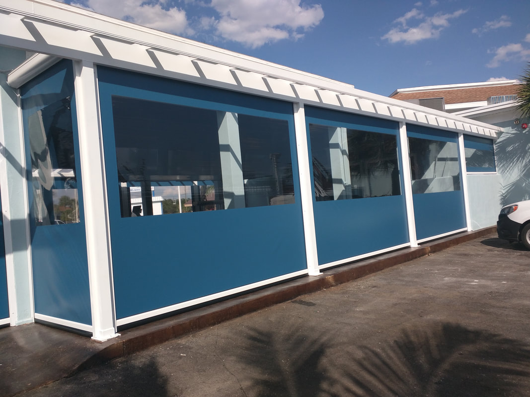 A blue and white building with a car parked in front of it