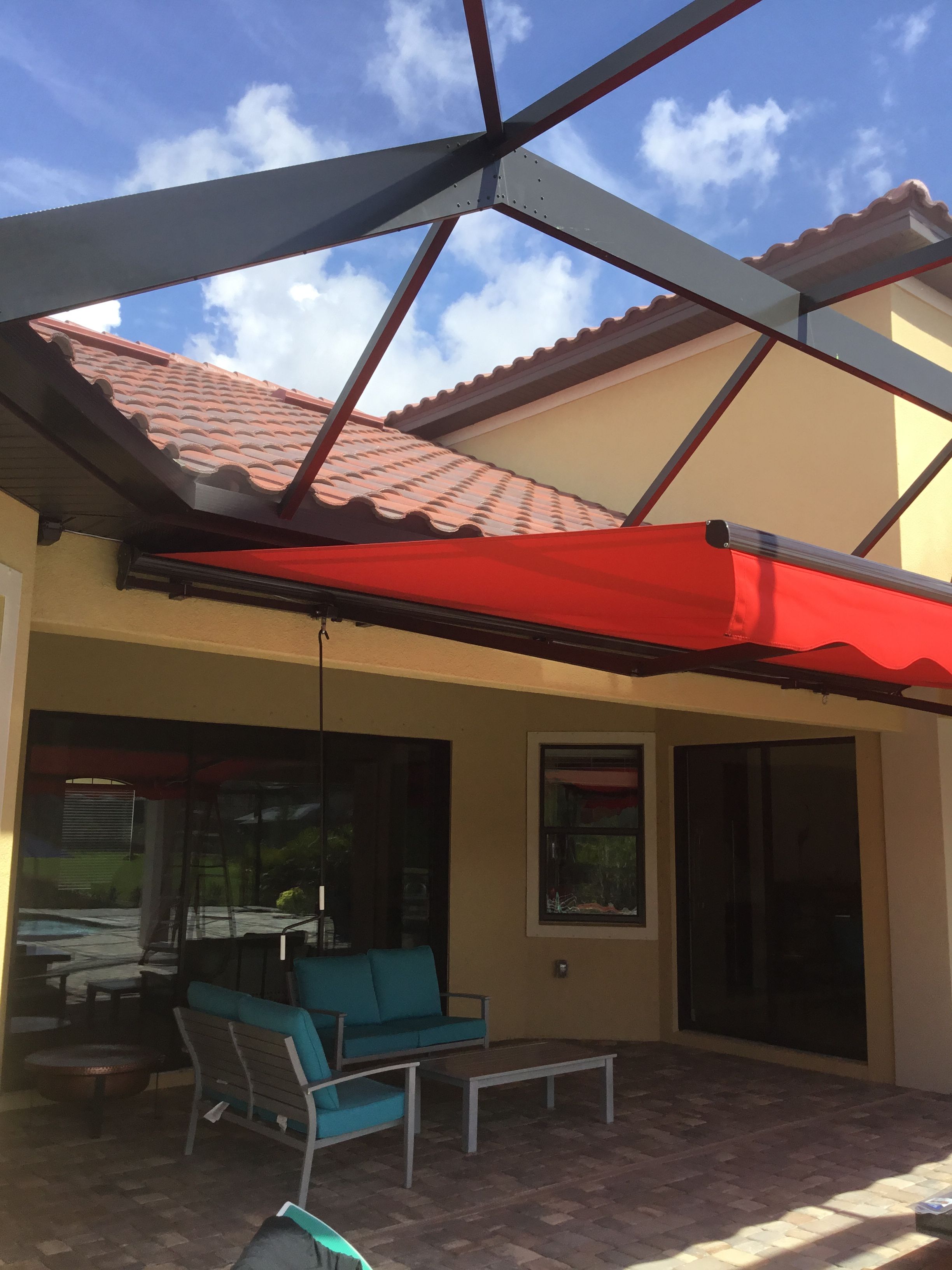 A patio covered with a red awning next to a building